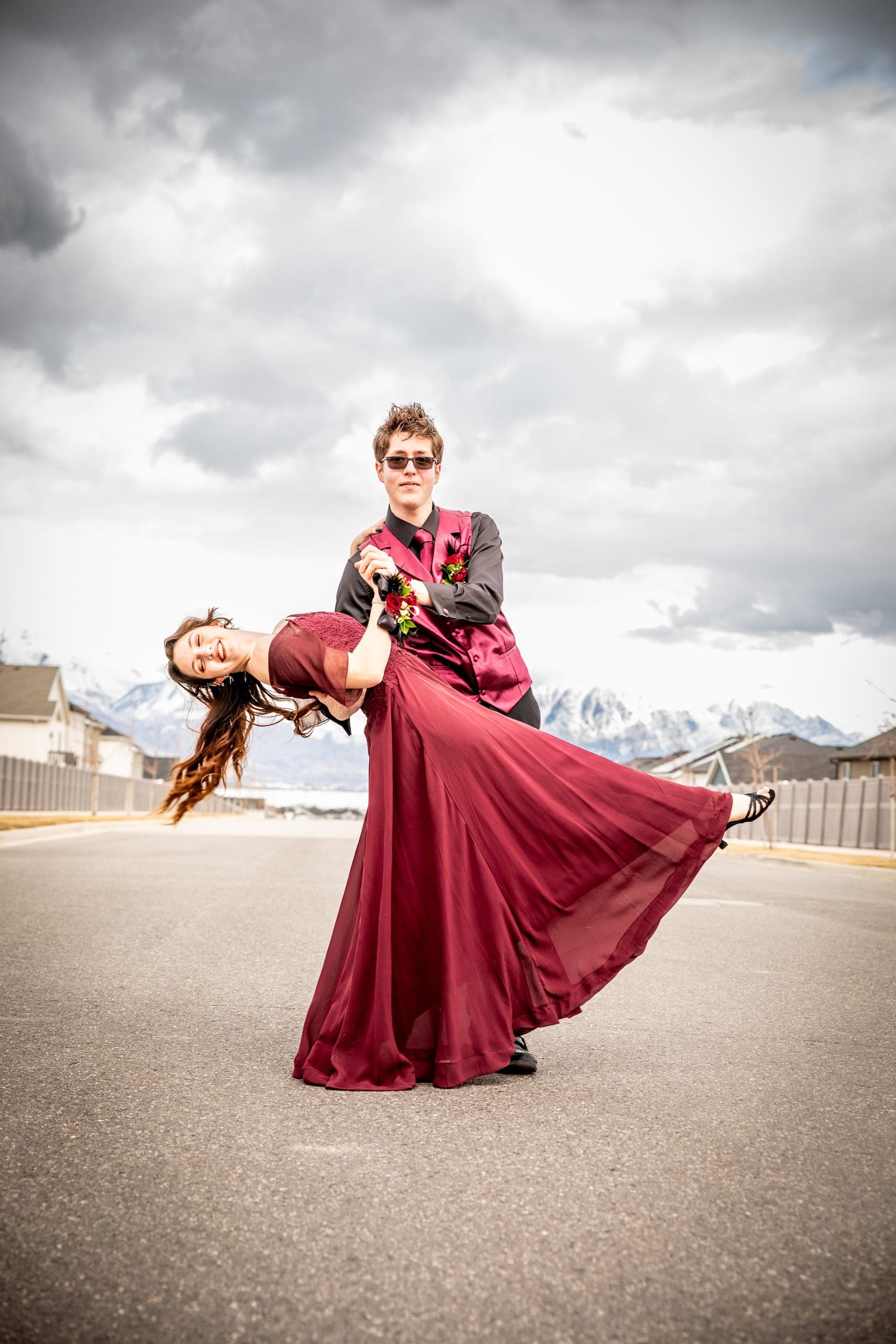 Couple dressed for a formal dance doing a dip in the street