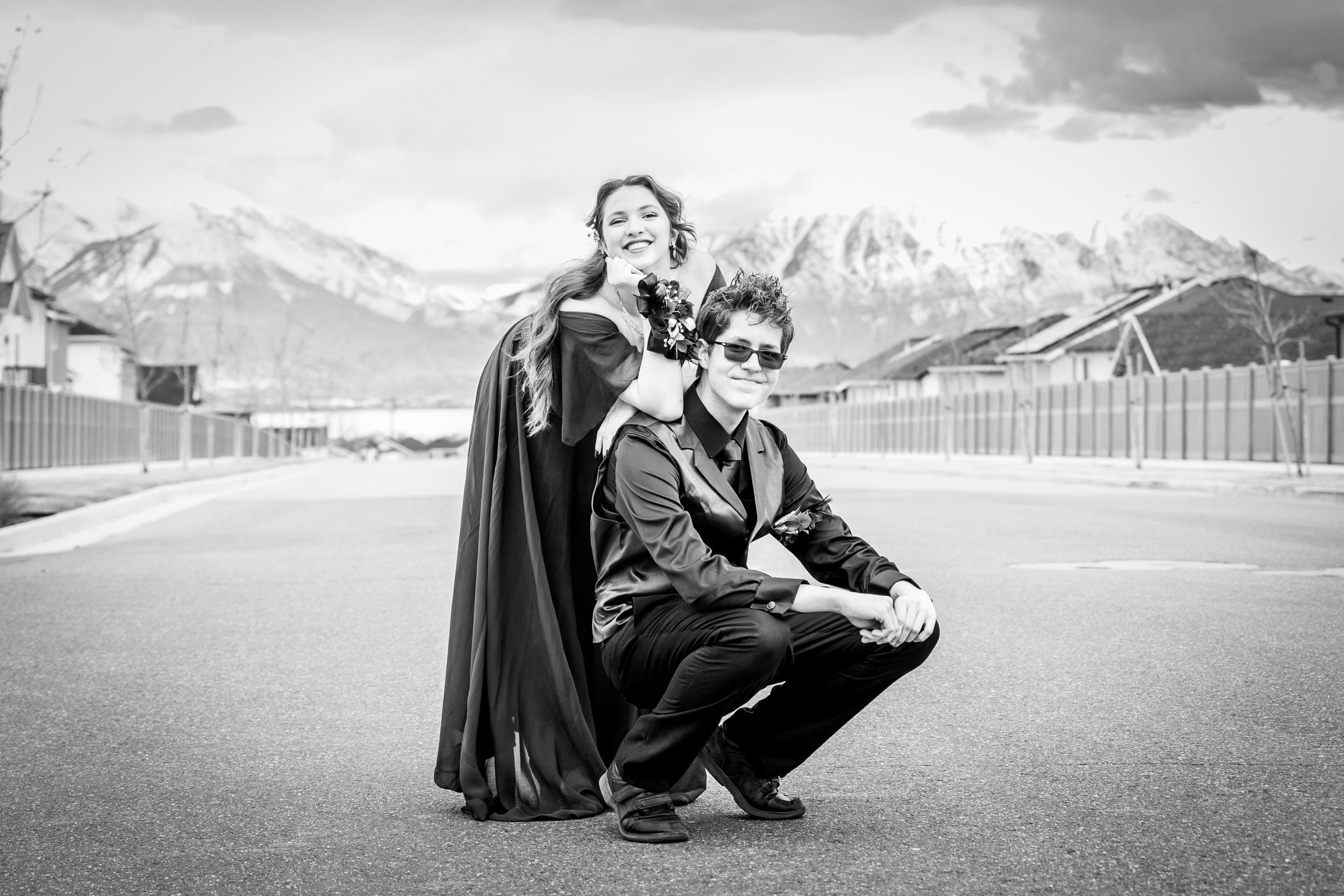 Black-and-white photo of a couple in formal wear with mountains behind