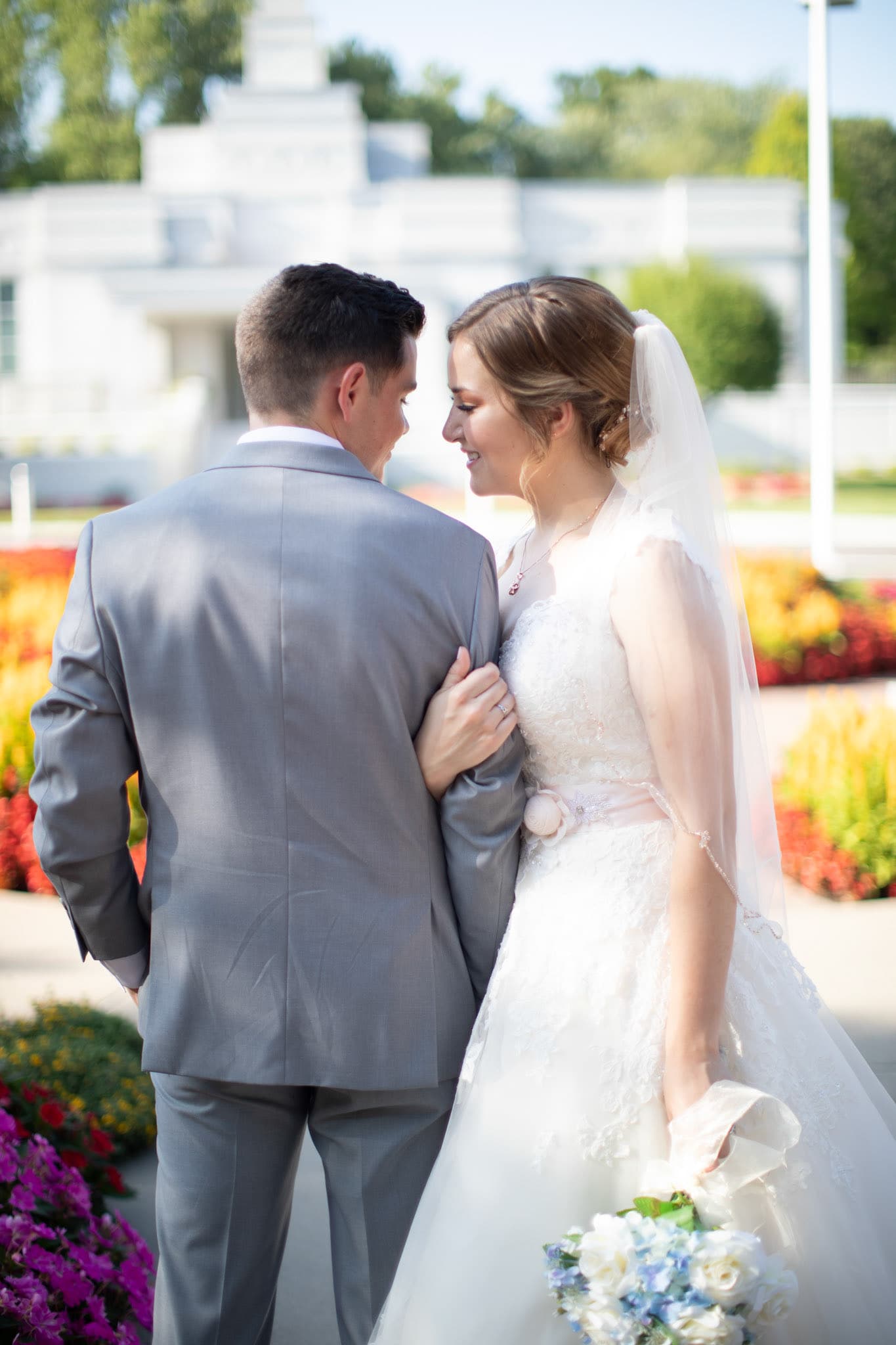 Bride and groom embracing in a flower garden