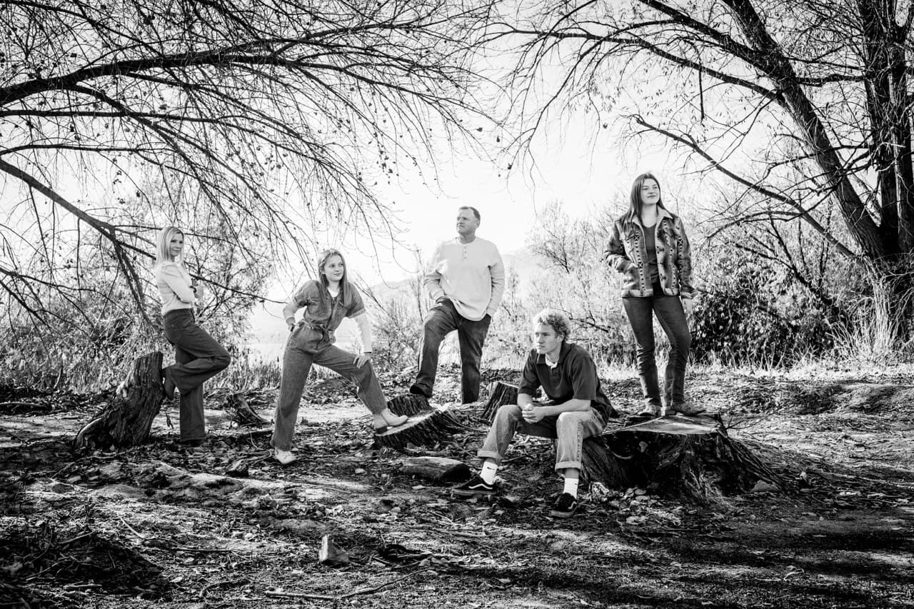 Black-and-white family photo among bare trees