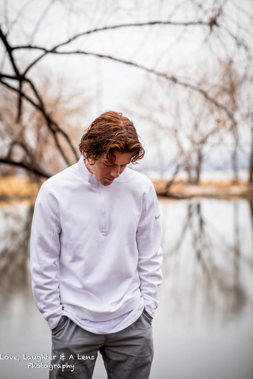 Teen in a white pullover beside a lake in winter