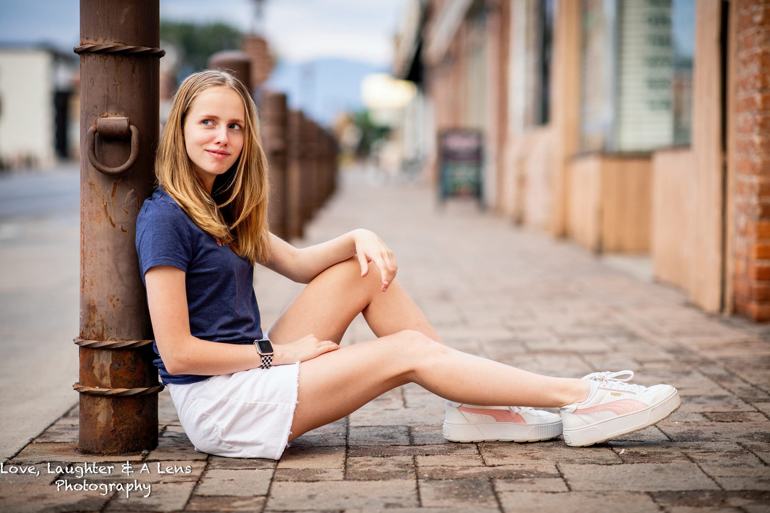 Teen sitting on a downtown sidewalk