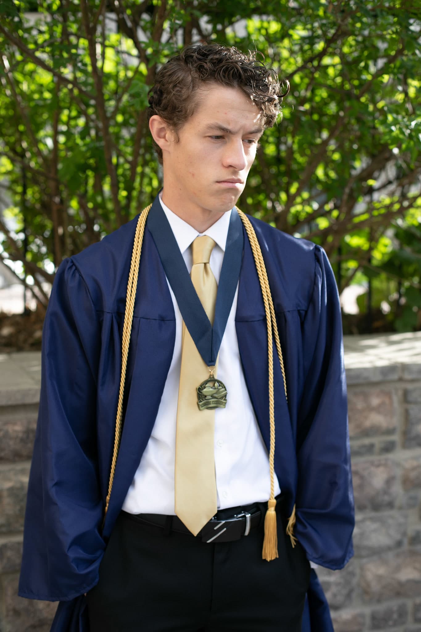 Graduate in a navy gown with a medal and gold stole