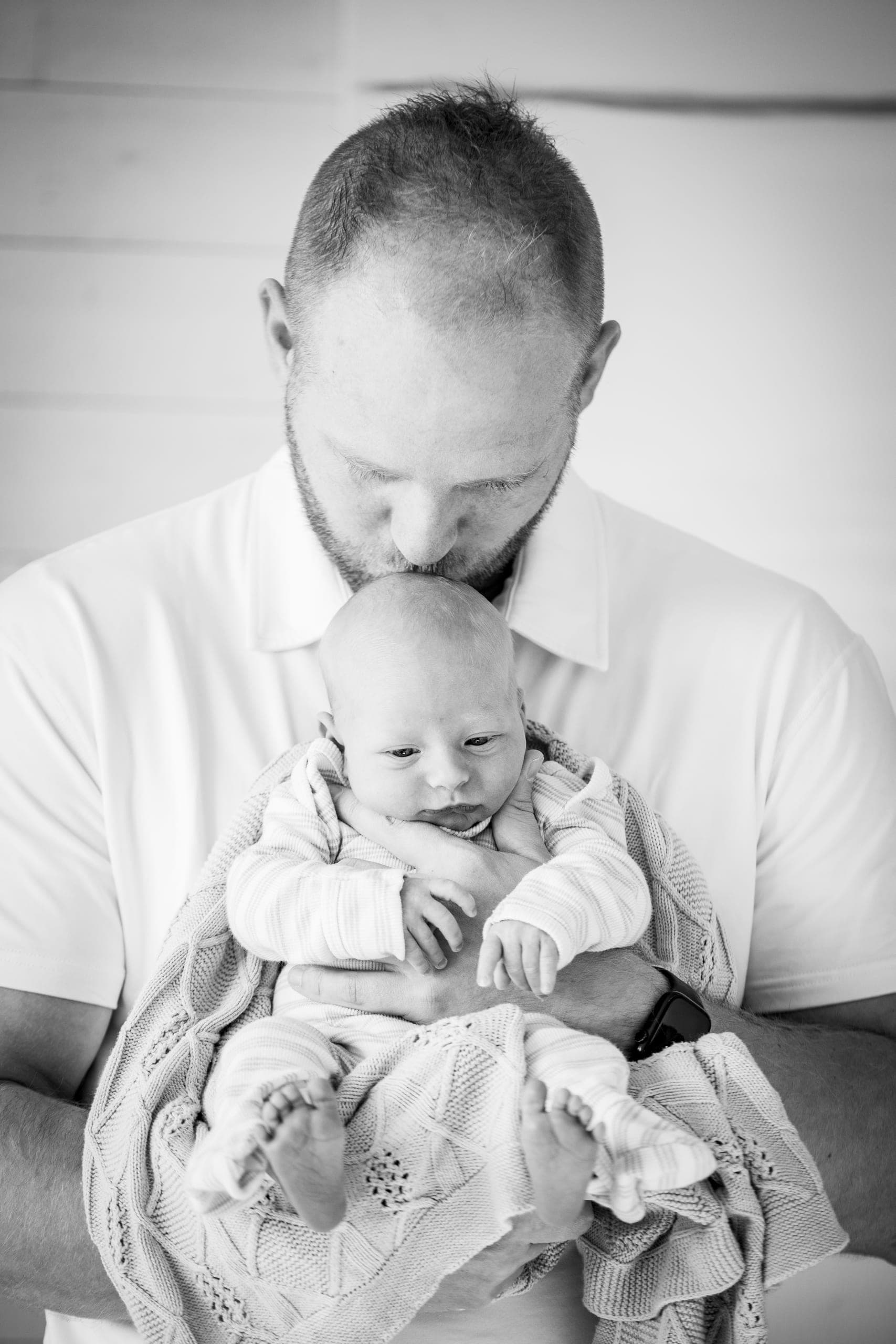 Parent holding a newborn, in black and white