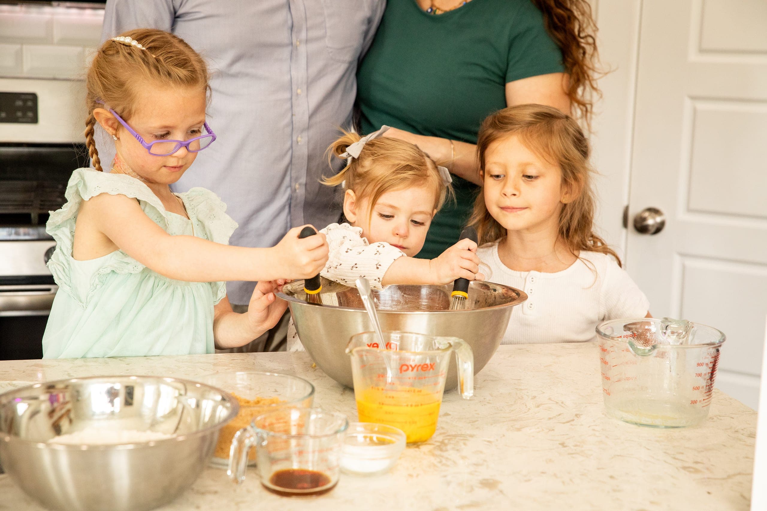 Kids baking with their parents in the kitchen
