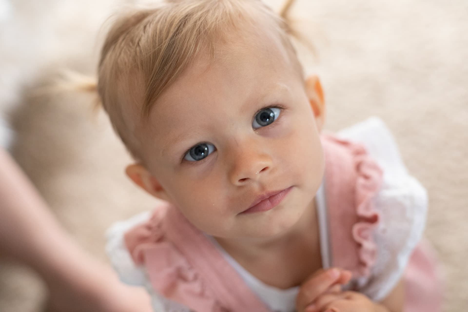 Close-up of a toddler looking up at the camera