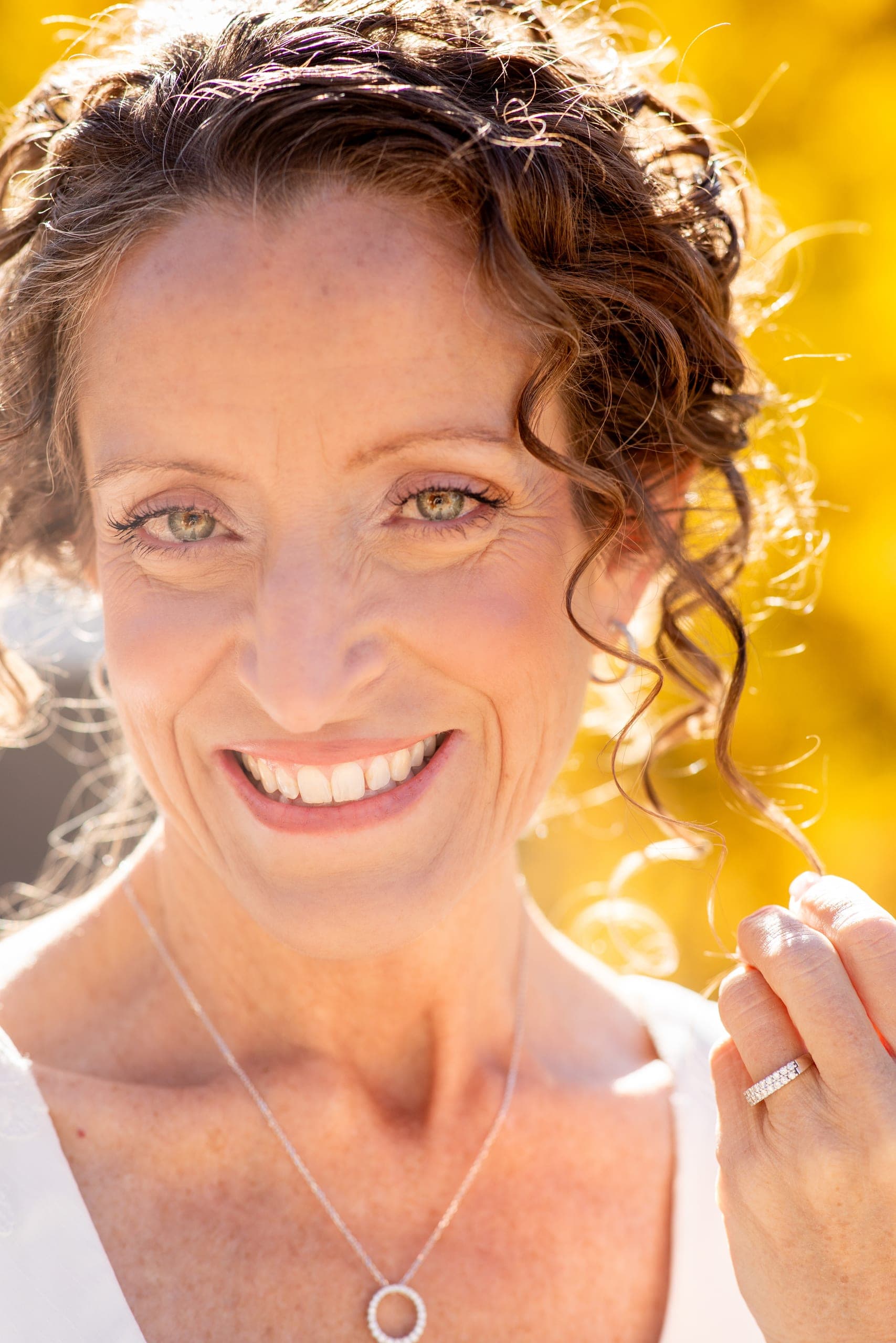 Close-up of a smiling bride with yellow aspens behind