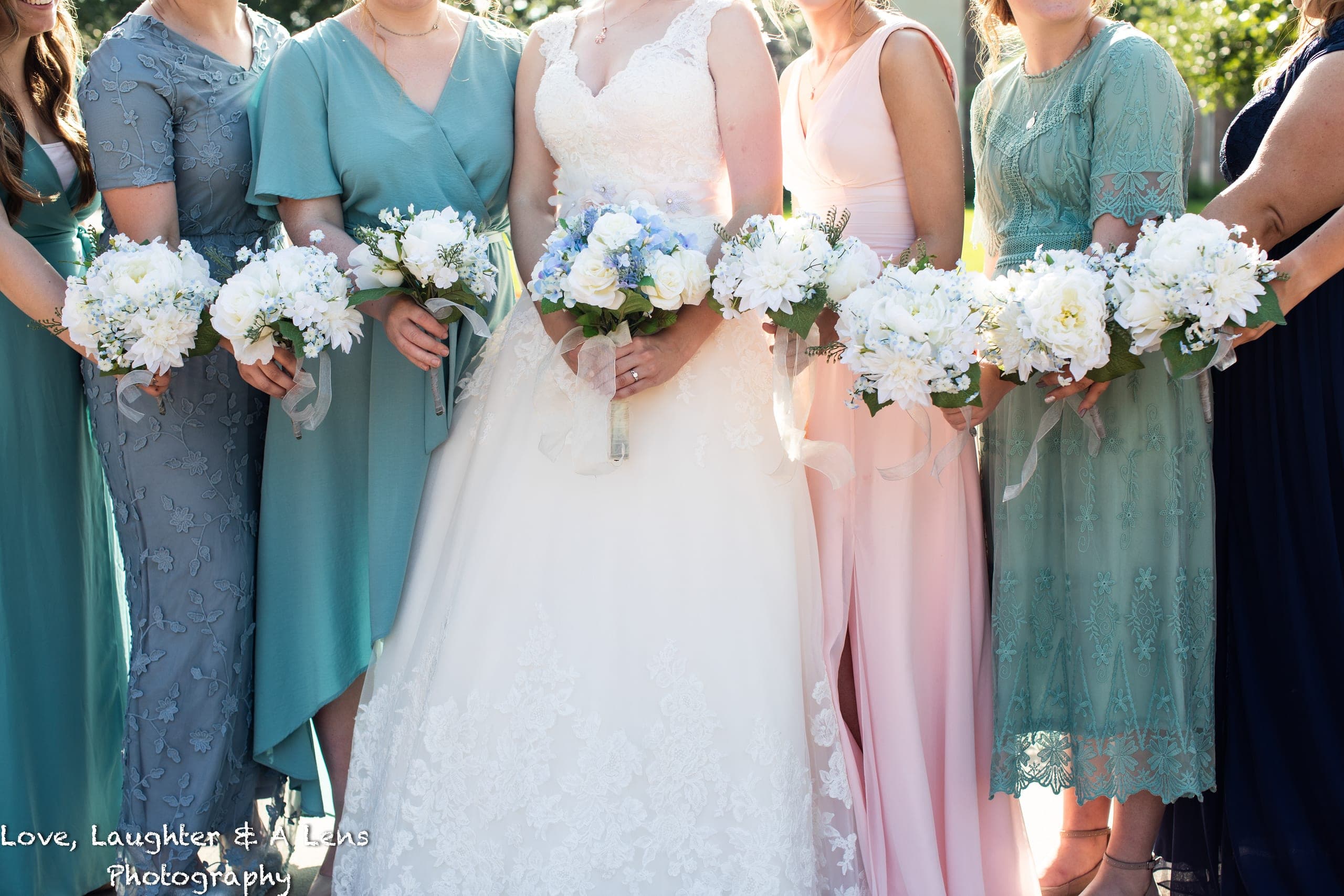 Bride with bridesmaids holding white bouquets