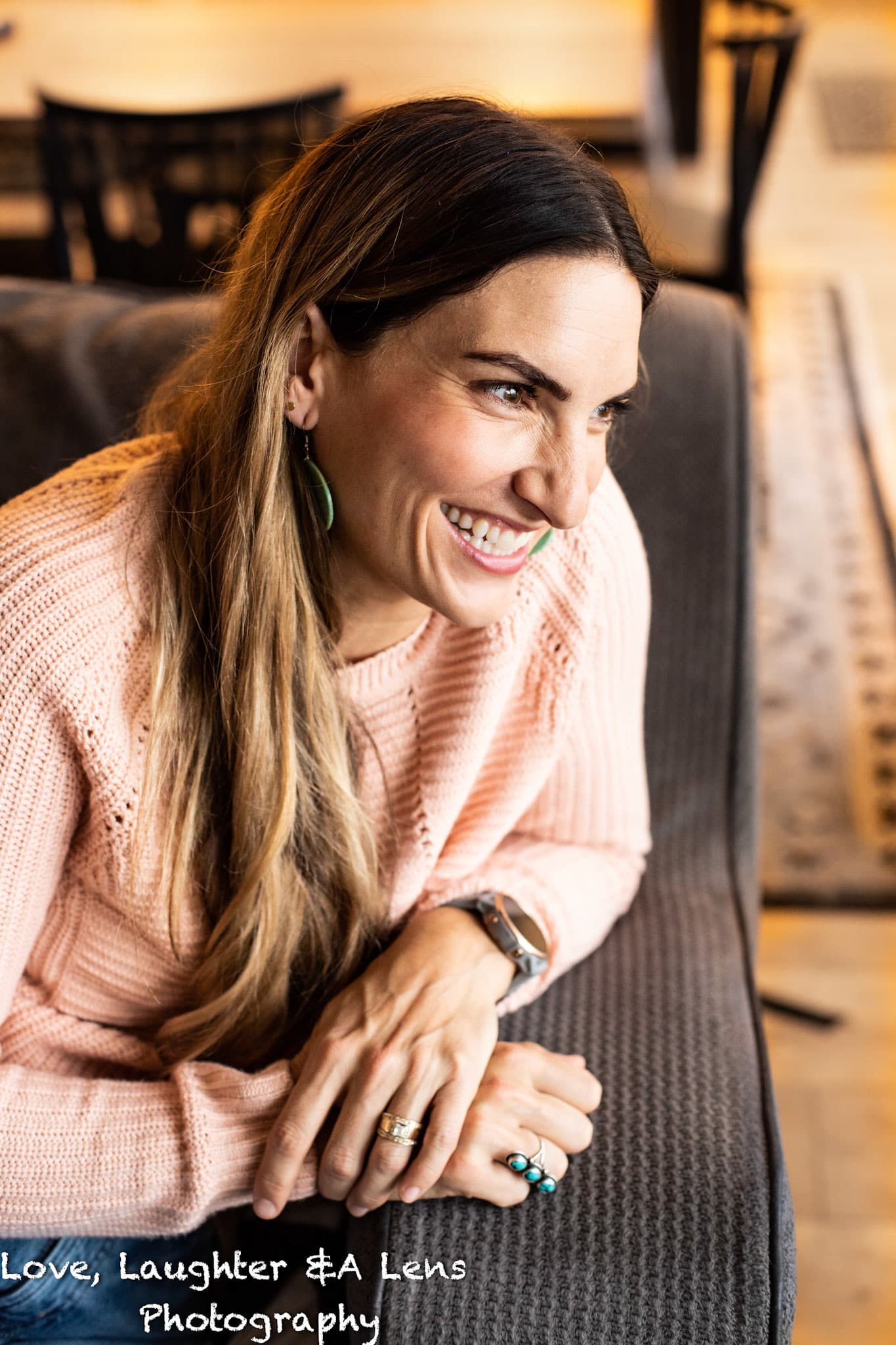 Woman in a pink sweater laughing at home