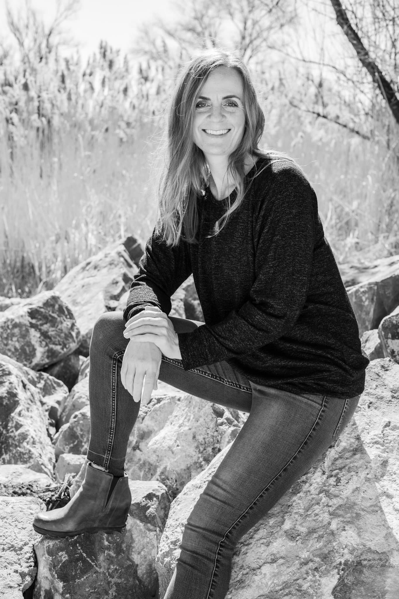 Black-and-white portrait of a woman sitting on rocks