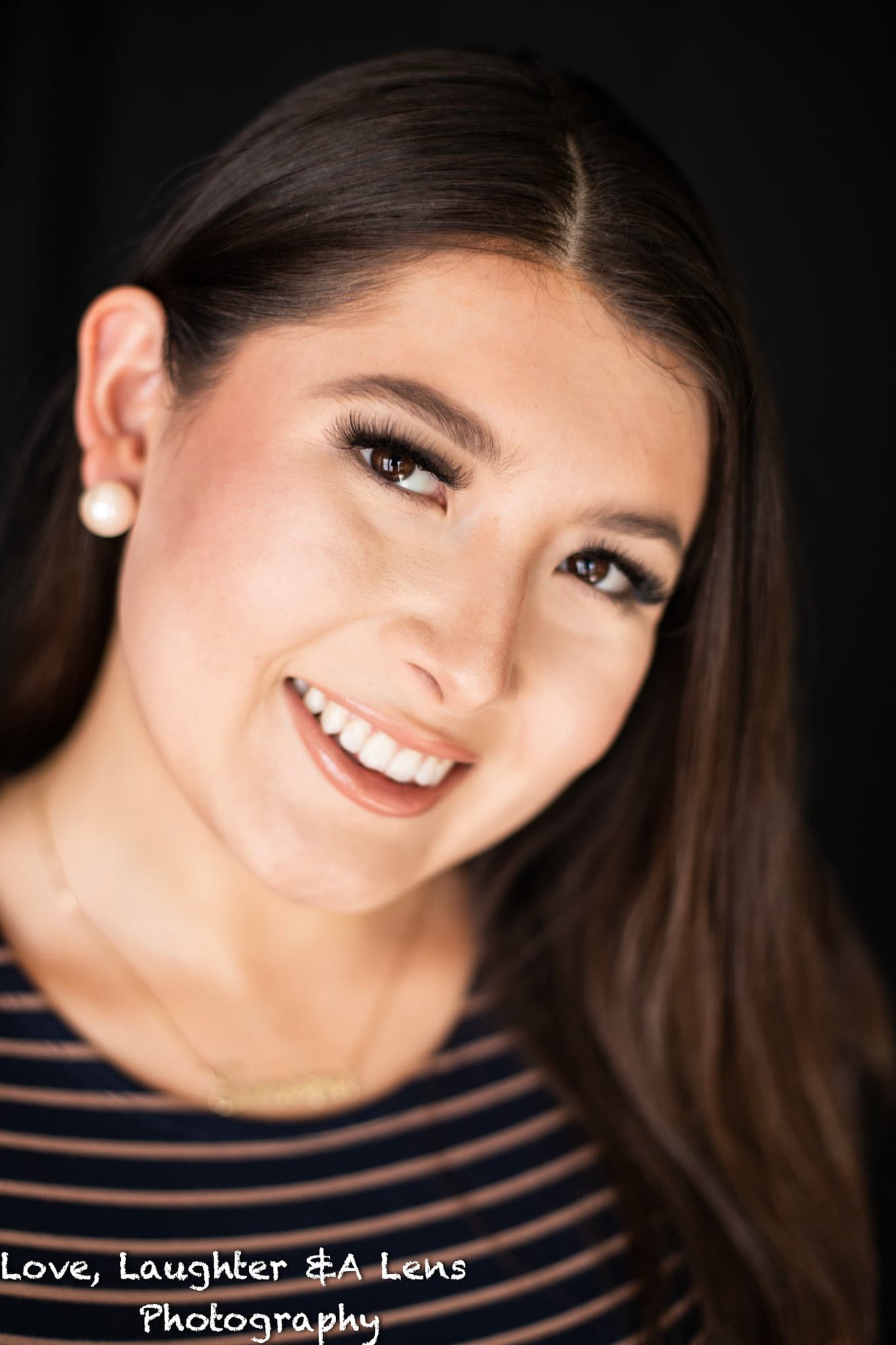 Close-up portrait of a smiling woman on a dark background